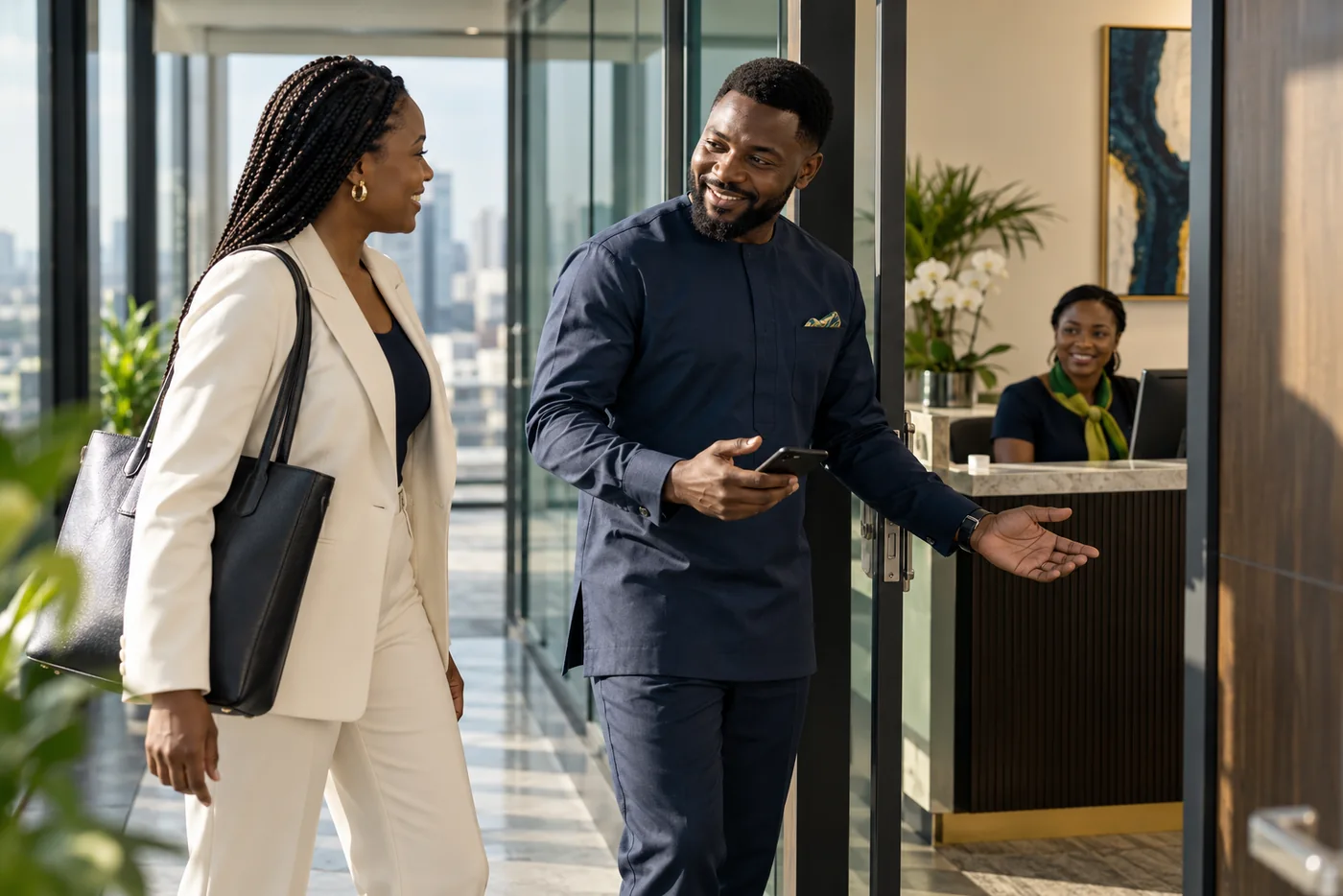 Workplace host greeting an arriving visitor near an office doorway